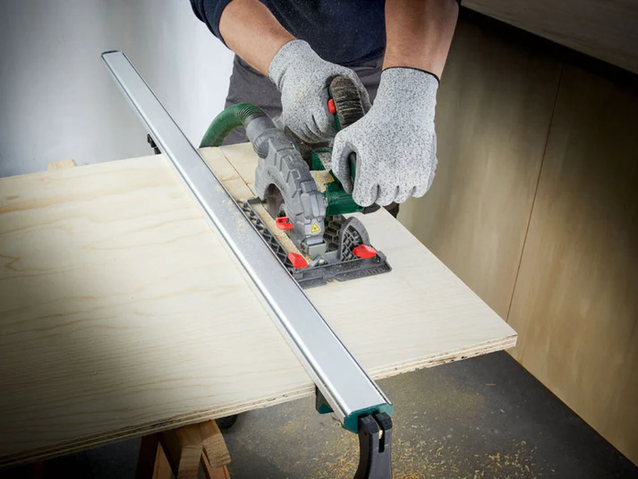 Sega circolare in uso con guida parallela per tagli precisi su tavola di legno